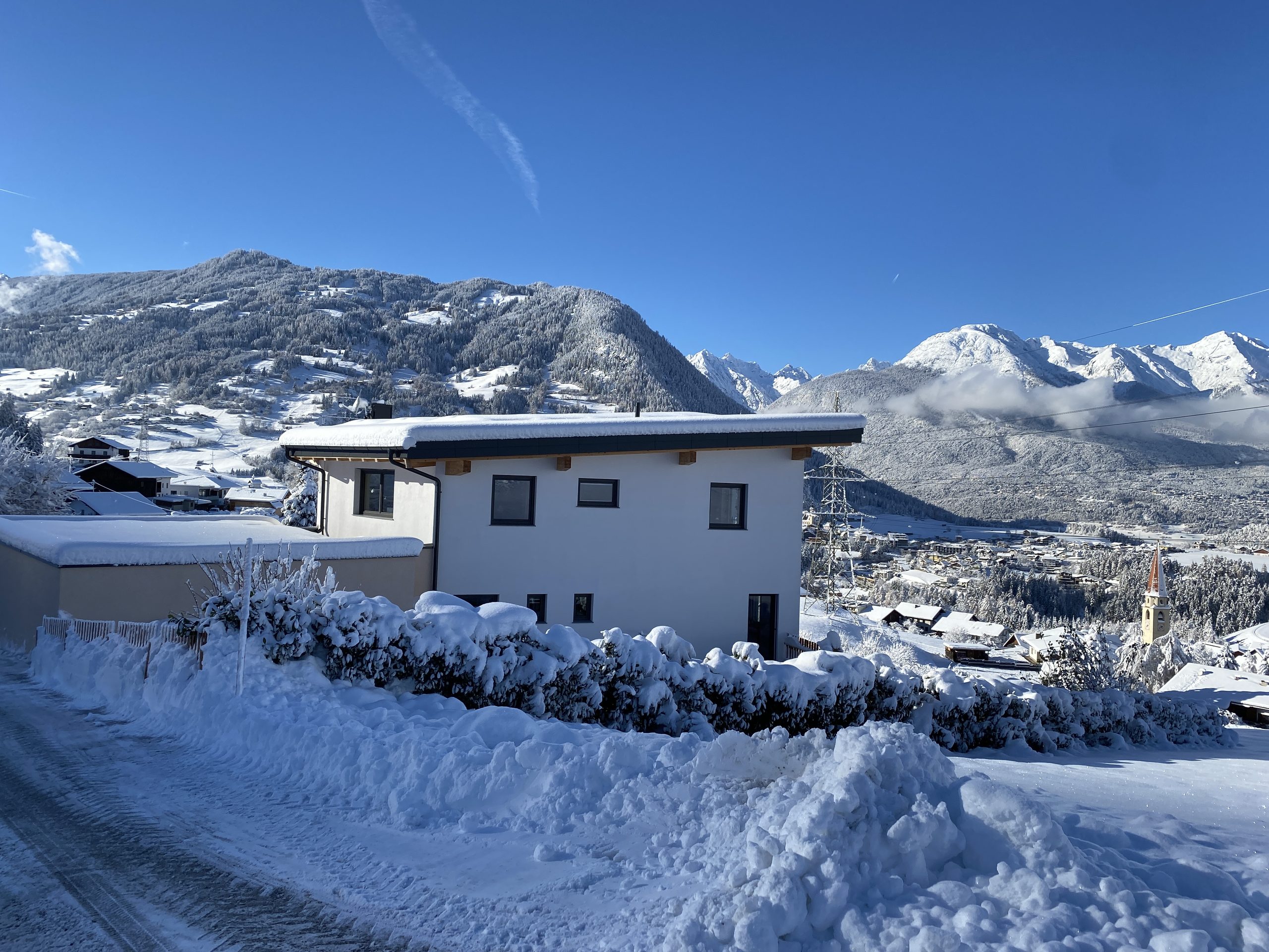 Apart Bergliebe im Winter mit verschneitem Garten und Bergpanorama